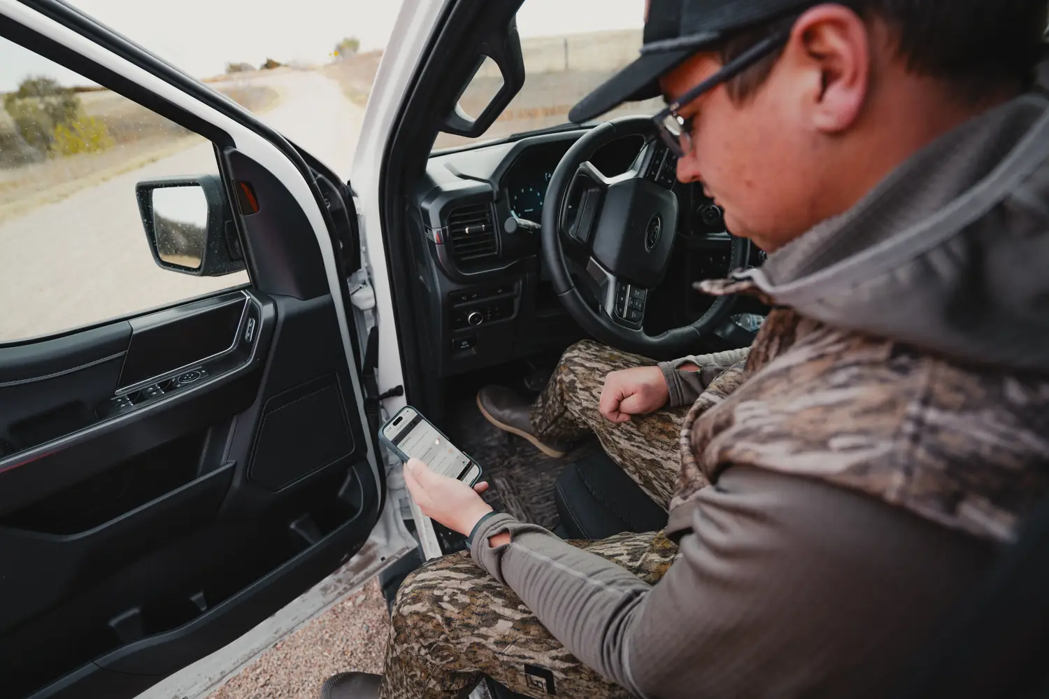 An outfitter checking bookings on the Mallard Bay app from his truck