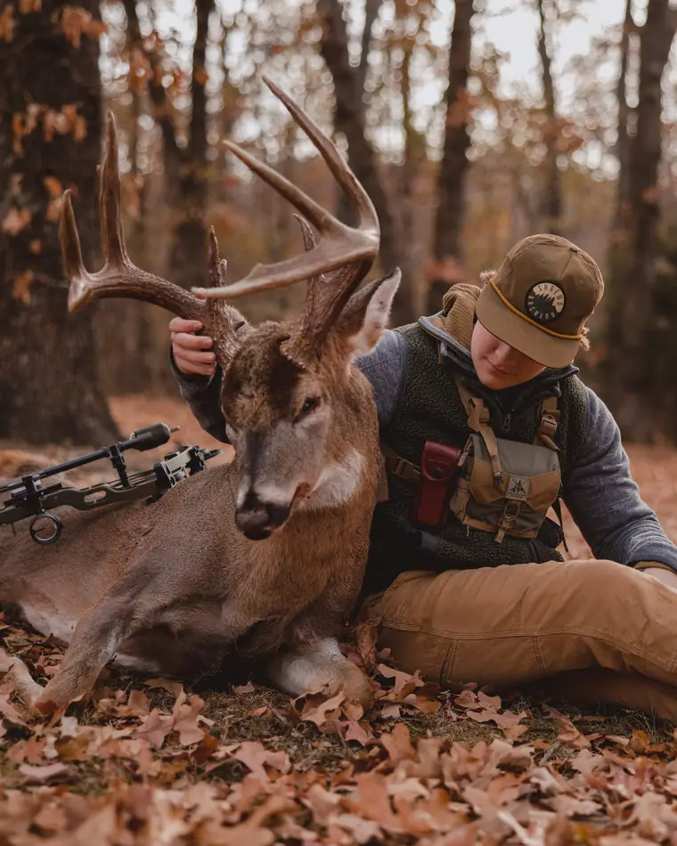 A bowhunter with a whitetail buck